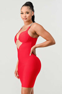 Plunging Red Dress with Metallic Straps: This stunning red dress showcases a plunging neckline, metallic chain straps, and a sheer cut-out at the waist. The bodycon fit highlights the curves for a sleek and sexy look.