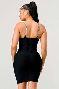 Elegant Black Bodycon Dress with Chain Straps: A chic black bodycon dress with a plunging neckline, chain straps, and a sheer V-shaped cut-out at the waist. The dress is designed to fit closely to the body, showcasing the curves.