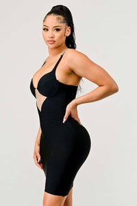 Black Bodycon Dress with Chain Straps: A sleek black bodycon dress featuring chain straps and a plunging neckline with a sheer V-shaped cut-out. The dress contours the body, enhancing the figure.