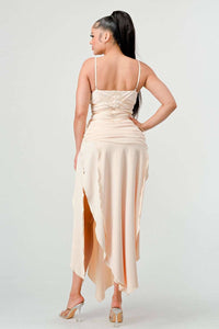 Beige spaghetti strap dress featuring ruched sides and a high slit