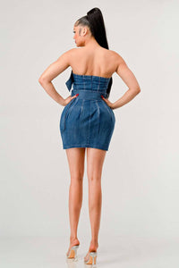 Model showcasing a strapless denim dress with pleated front and belts