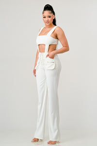 Refined white ensemble with a daring square-neck crop top and flattering high-waisted trousers with unique lace-up sides.