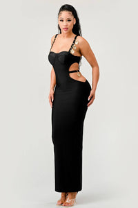 Black Evening Dress with Cut-Out Sides and Gold Details: A black maxi dress with a bodycon fit, featuring cut-out sides and gold-accented straps. The dress combines elegance and modernity for a striking appearance.